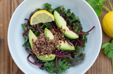 Healthy vegetarian lunch of kale, quinoa, avocado, beets and lemon vinaigrette