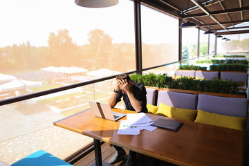 Freelance copywriter rewrite text on laptop at cafe table.