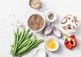 Flat lay healthy vegetarian food ingredients for lunch on a light background, top view. Buckwheat, green beans, sweet peppers, red onion, mushrooms - clean eating vegetarian food concept - obrazy, fototapety, plakaty