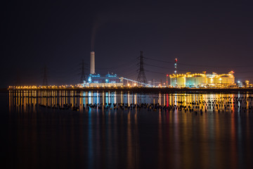Fototapeta na wymiar Night light at the factory near the ocean, Oil Refinery factory , petrochemical plant , Petroleum 