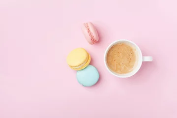 Keuken spatwand met foto Cup of coffee and colorful macaron on pastel pink background top view. Cozy breakfast. Fashion flat lay. Sweet macaroons. © juliasudnitskaya