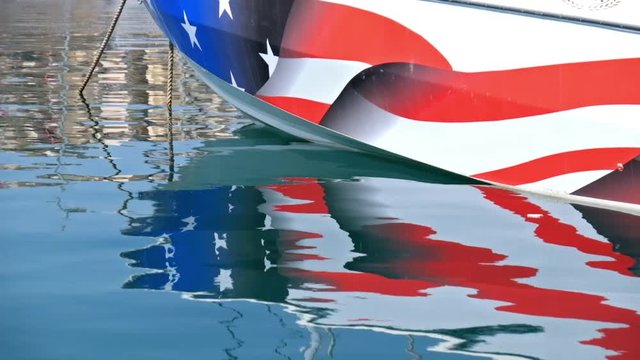 Reflection of Yacht board with american flag  in water