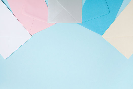 Colorful envelopes on blue table top view. Mockup for business mail, blogging and office correspondence. Flat lay style.