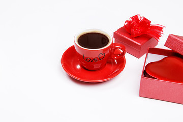 Red coffee cup, red heart in red gift box on white background with copy space. Close up. Happy new year. Valentines day background.