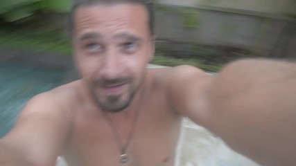 Young adult man spinning around on beach having fun taking video selfie. Closeup, hand held, outdoor sunny daylight shot.