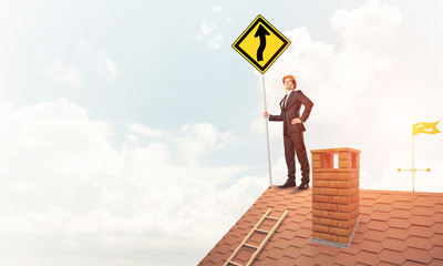 Engineer man on brick roof with sign in hands. Mixed media