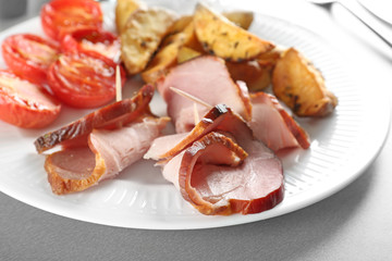 Plate with sliced honey baked ham and garnish, closeup