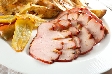 Plate with sliced honey baked ham and vegetables, closeup