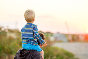 Father and son outdoor portrait in sunset sunlight