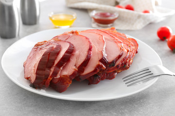 Plate with yummy sliced honey baked ham on table, closeup