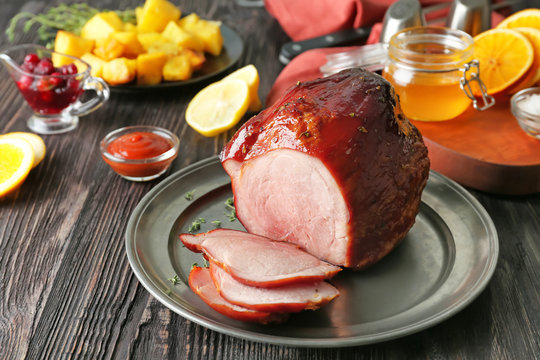 Metal plate with traditional honey baked ham on table