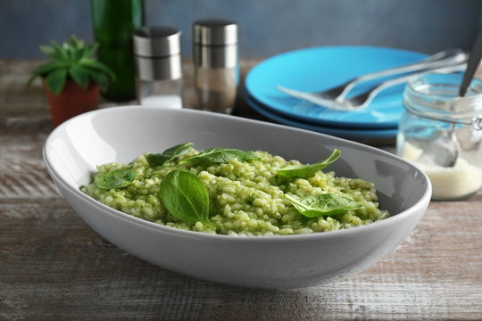 Dish with tasty spinach risotto on table