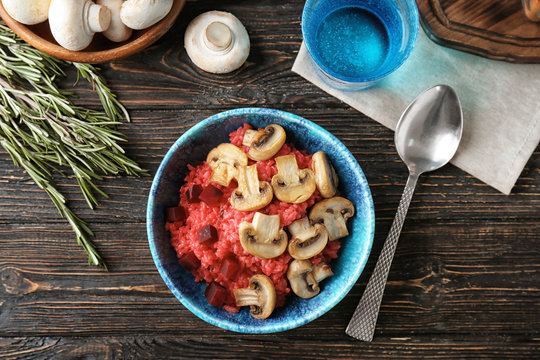 Dish with tasty risotto with mushrooms  on table, top view