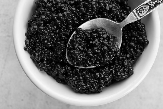 Ceramic bowl and spoon with black caviar, closeup