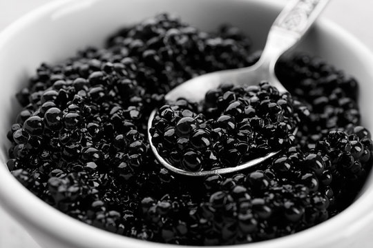 Ceramic bowl and spoon with black caviar, closeup