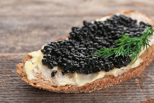 Bread with black caviar and butter on table