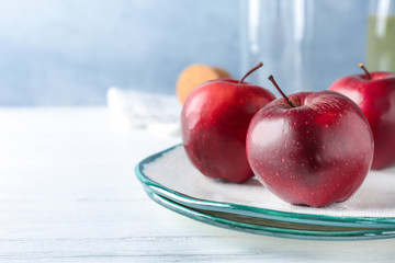 Plate with ripe red apples on table