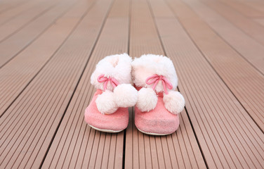 Pair of baby fashion shoe on wood plank background. Shoes for winter season.