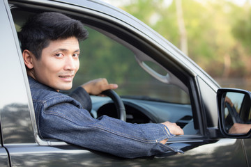  Handsome man  smiling  in his car and looking at camera   - transportation and lifestyle concept.