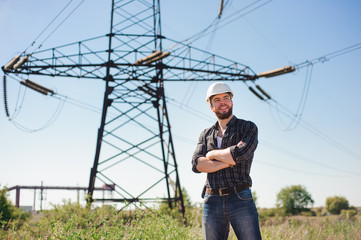 Engineer with white hard hat under the power lines.Engineer work at an electrical substation.