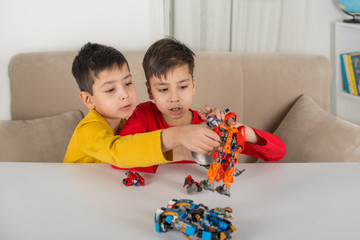 the boys sit on sofa and the designer robots