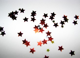 Confetti of shiny stars on a white background