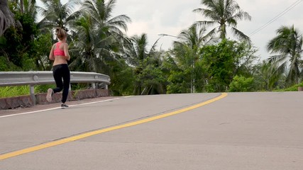 fitness woman running at tropical forest trail