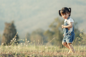 Naklejka na ściany i meble Happy child running outdoors. Little girl playing around the park on beautiful morning. Healthy preschool children summer activity. Kids