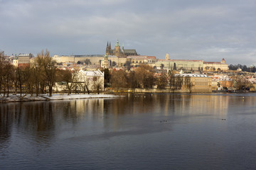 Fototapeta na wymiar Snowy Prague Lesser Town with Prague Castle, St. Nicholas' Cathedral and Charles Bridge, Czech republic
