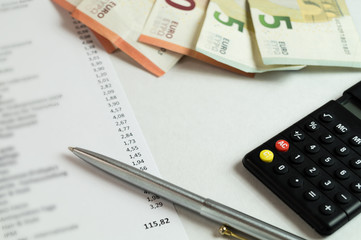 buchführung - geldscheine mit taschenrechner und quittungen auf dem schreibtisch