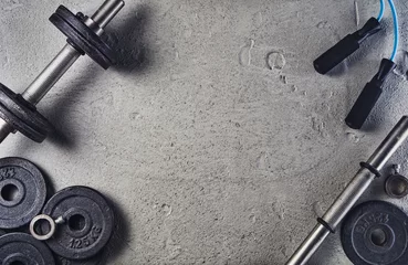 Rollo Fitness- oder Bodybuilding-Konzepthintergrund. Produktfoto von alten Eisenhanteln auf grauem Betonboden in der Turnhalle. Foto von oben aufgenommen, Draufsicht mit viel Platz für Kopien © wstockstudio