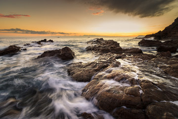 Fototapeta na wymiar mer agitée sur la côte au coucher de soleil