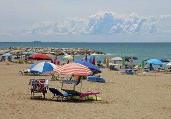 beach with sun beds and umbrellas during the summer holidays