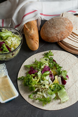 vegetarian lavash with fresh herbs and bread on a dark background