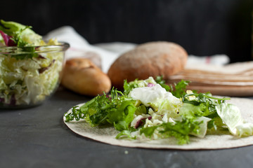 vegetarian lavash with fresh herbs and bread on a dark background