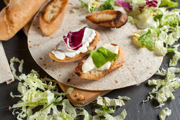 sandwiches with fresh herbs, sour cream and cheese and bread on a dark background