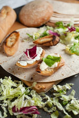 sandwiches with fresh herbs, sour cream and cheese and bread on a dark background