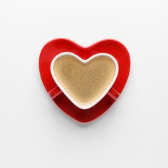 Red heart shape coffee cup on white background. Flat lay, top view.