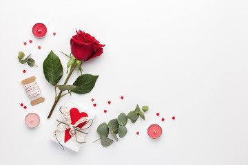 Frame made of rose flower, gift and candles on white background. Valentines day background. Flat lay, top view, copy space.