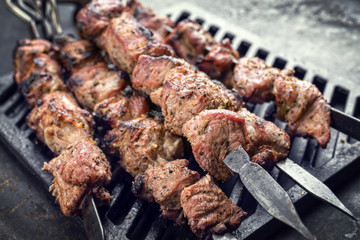 Traditional Russian shashlik on a barbecue skewer as top view on grillage