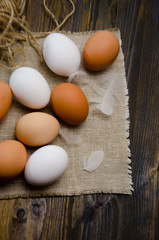 eggs on wooden background and feathers