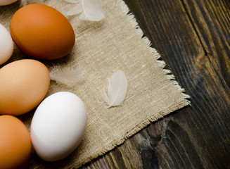 eggs on wooden background and feathers