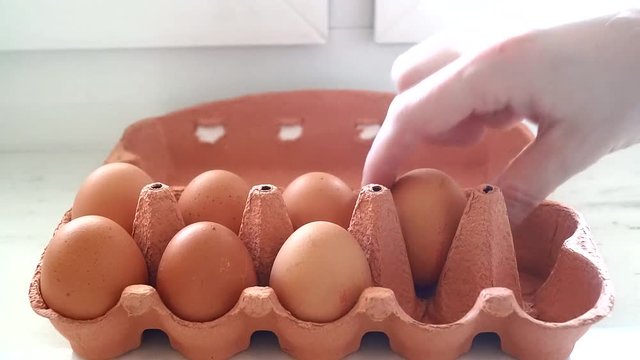 hand put eggs into a box