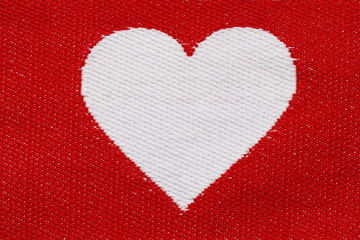 Embroidered white heart on a red background