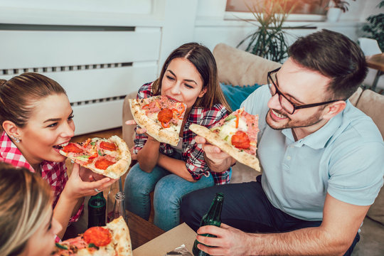 Group of young friends eating pizza.Home party.Fast food concept.