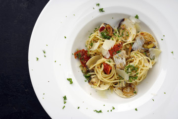 Spaghetti alle Vongole mit Tomaten Pesto als Draufsicht auf Teller mit Textfreiraum links