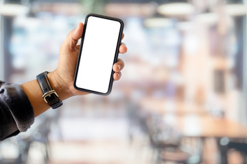 Mock up smart phone in man hand in cafe. Blank screen for graphic display montage.