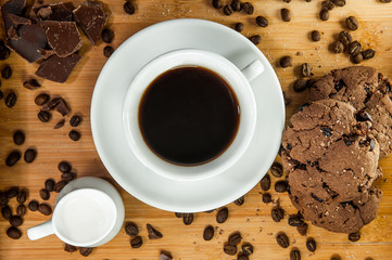 A cup of coffee with biscuits on a wooden tray
