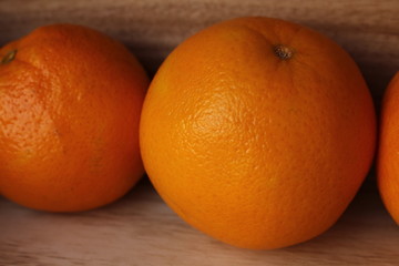 Fresh whole oranges in a box on a wooden background