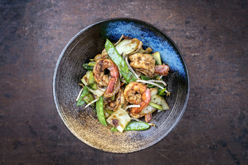 Traditional stir-fried Thai phak kung as top view in a bowl with copy space
